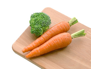 Fresh carrots and brocoli on wooden plate