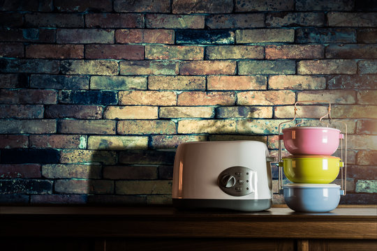 Colorful tiffin carrier and toaster on wooden cupboard with vint