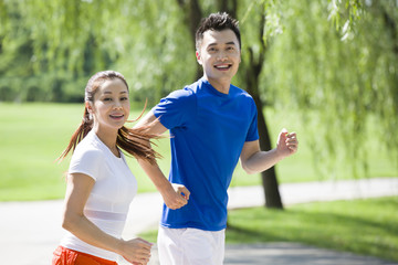 Fototapeta na wymiar Young couple jogging in park