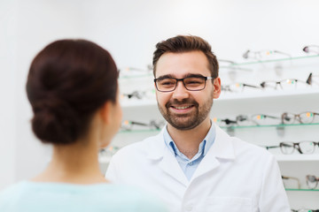 woman and optician in glasses at optics store