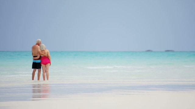 Mature Caucasian couple in swimwear outdoors together on tropical beach 