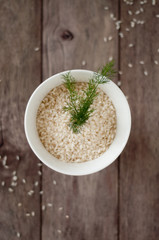 Tazza bianca con chicchi di riso crudo e finocchio selvatico 