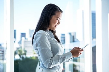 Fototapeta premium Smiling businesswoman using smartphone