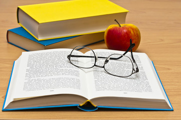 Bücher, Brille und Apfel