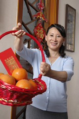 Woman Celebrating Chinese New Year Holding A Basket Of Oranges