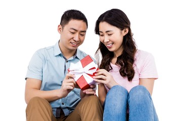 Cheerful couple holding gift box