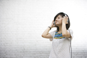 Young woman listening to music on headphones