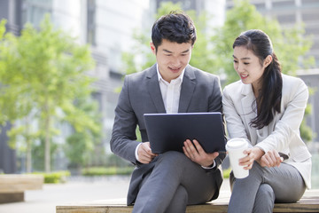 Young business person working with laptop outdoors