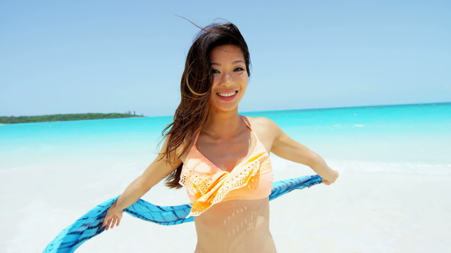 Smiling Asian Chinese girl in swimwear on beach vacation