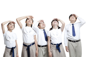 Obraz premium Schoolchildren looking up with hands shielding eyes from the sun