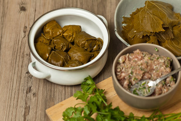 Old woman making Stuffed Grape Leaves. Dolma. Azerbaijan, Turkish and Greek Cuisine. Selective focus.