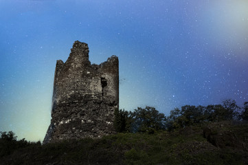 Old castle tower on a night sky background