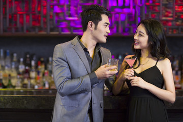 Young man and woman flirting at bar