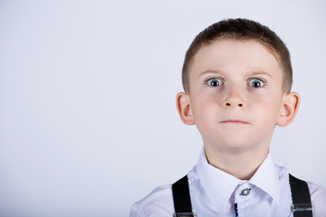 Stubborn little boy,child with wide opened eyes  isolated over yellow background.Facial expression