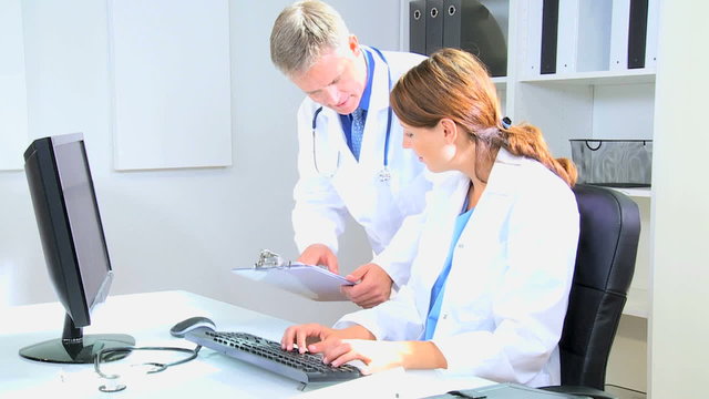 Western European male female doctor medical executive team computer technology