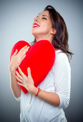 Young woman in love clutching a red heart
