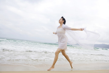Portrait of a young woman running along the beach