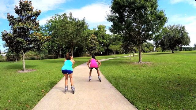 Young active multi ethnic women enjoying inline skating outdoor