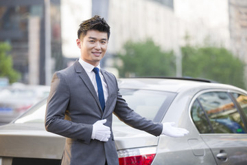 Portrait of chauffeur standing next to the car