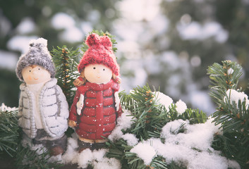 Two ceramic dolls at snow, toned