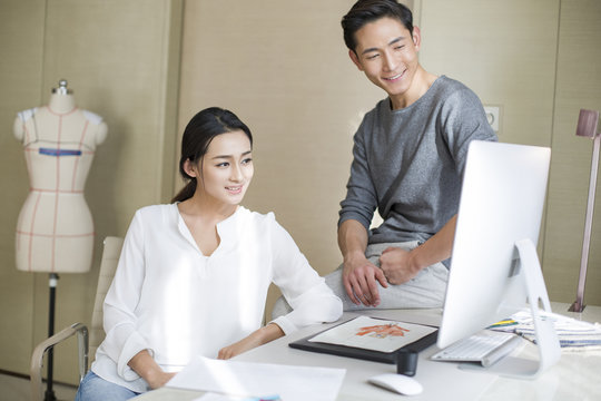 Young couple designing clothing together