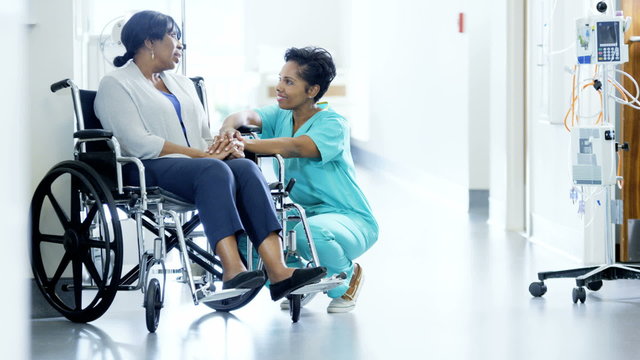 Portrait of African American female empathy nurse and patient on wheelchair