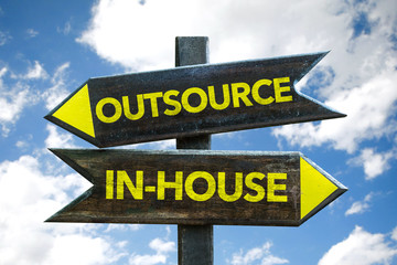 Outsource / In-House signpost with sky background