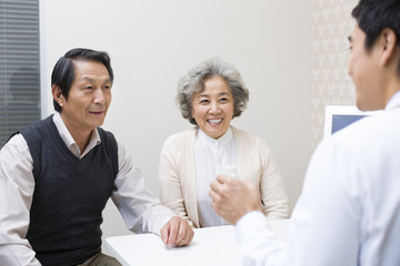 Doctor explaining dosage of medicine to senior couple