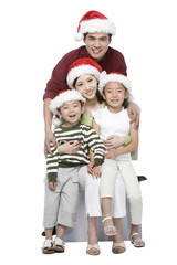 Fototapeta na wymiar Portrait of family of four with Santa hats