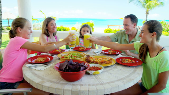 Young Caucasian family enjoying lunch outdoors at vacation resort