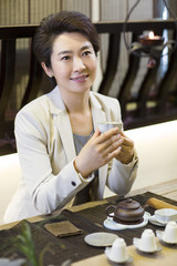 Businesswoman drinking tea in tea room
