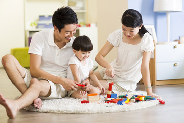 Young family playing building block