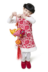 Happy girl with carp ornament celebrating Chinese new year