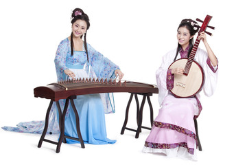 Young women in Chinese traditional costume plucking classical musical instruments