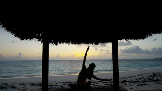 Girl in silhouette practicing yoga outdoor