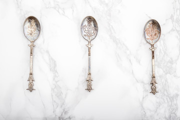 Old Vintage Dessert Spoons with Ornament on White Marble