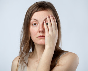 Portrait of a sad woman closing one eye