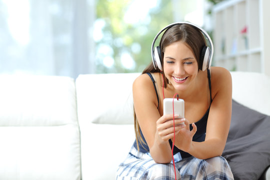 Girl listening music from smartphone at home