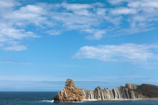 The picture represents a landscape of the Cantabrian coast, beach Portio in Liencres. The sea, blue sky and an rocks.