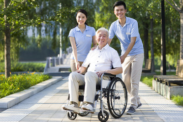 Wheelchair bound man with nursing assistants