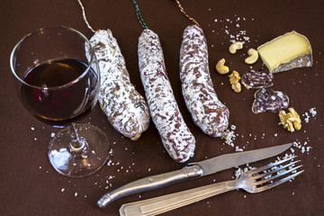Aperitif with red wine, saucisson, cheese and nuts