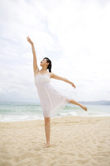 Fototapeta na wymiar A woman dancing at the beach