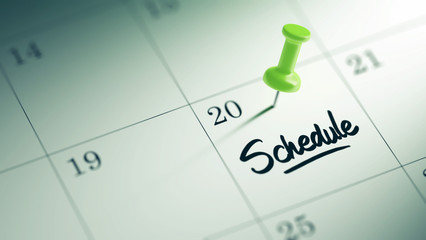 Concept image of a Calendar with a green push pin. Closeup shot