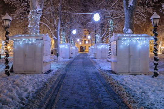 Zrinjevac park covered with snow in the cold winter night and closed stands on pathway