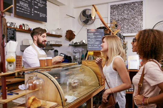 Young Women Friends Placing An Order In A Coffee Shop