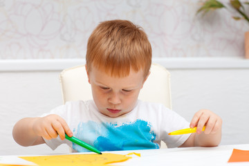 red-haired boy drawing on paper