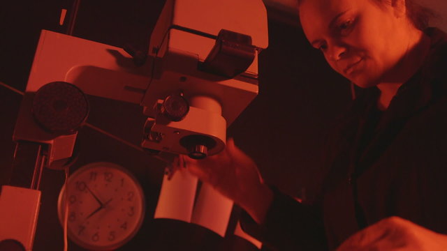 Photographer working in darkroom making photographs from camera films