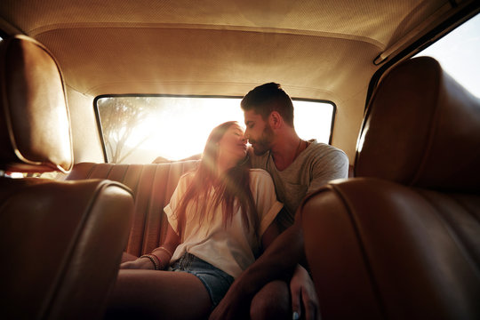 Romantic Young Couple In Back Seat Of Car