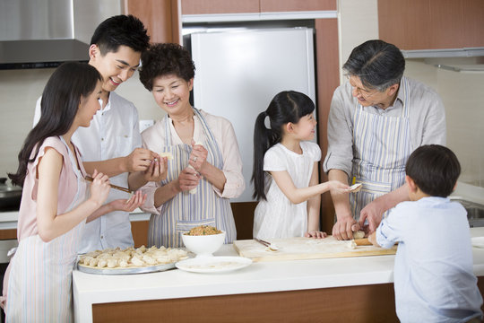 Happy family making dumplings - Powered by Adobe