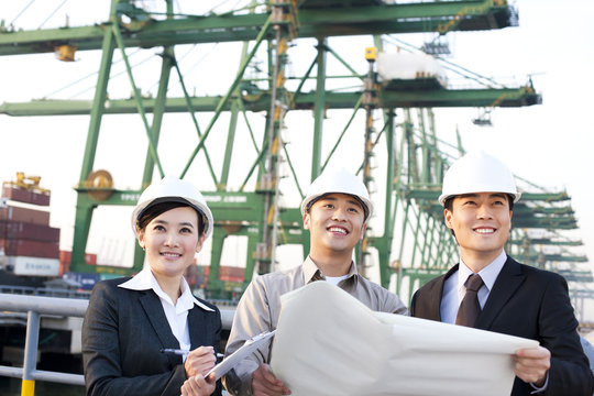 shipping industry professionals looking over blueprints in a row